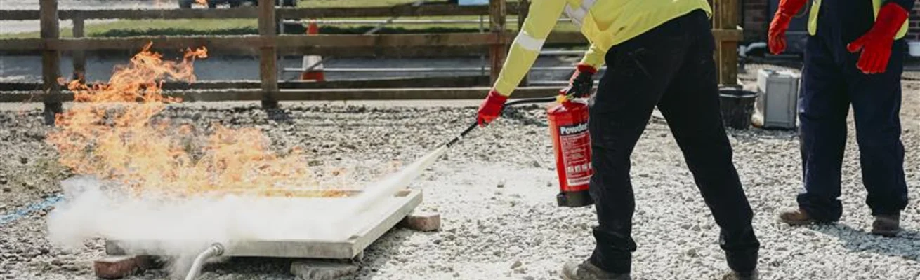 Course delegate extinguishes fire hazard on training site during incident management training