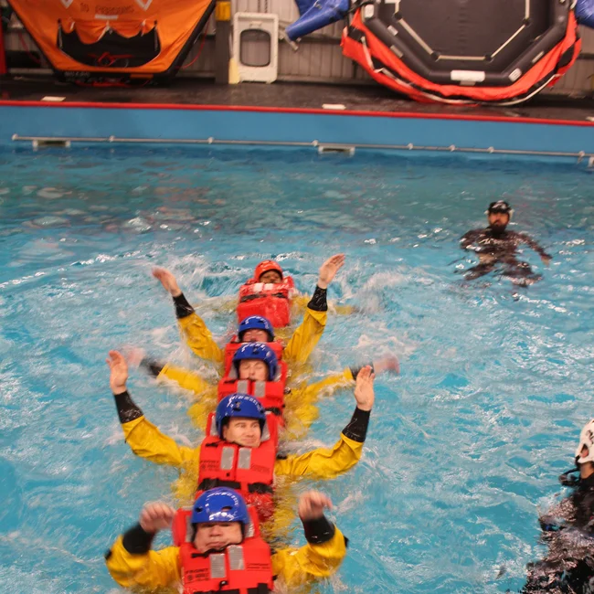 A group of BOSIET trainees wearing life vest in a pool