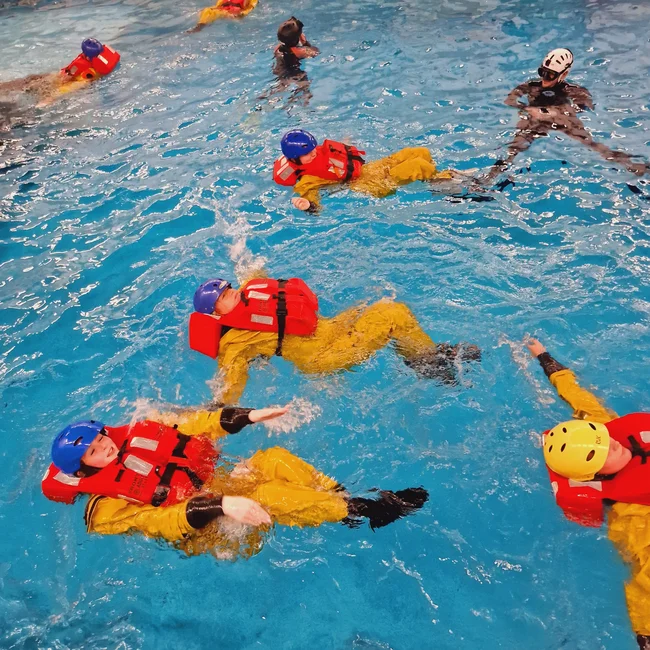 A group of BOSIET trainees wearing life vest in a pool