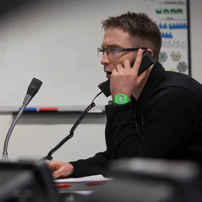trainer speaking on the landline in the command center for crisis management