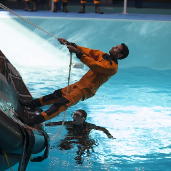 Trainee flipping an inflatable boat in indoor pool